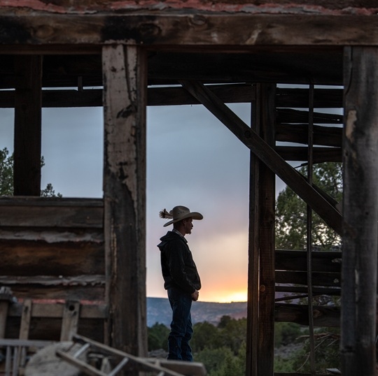 Cowboy in ban with sunset in background