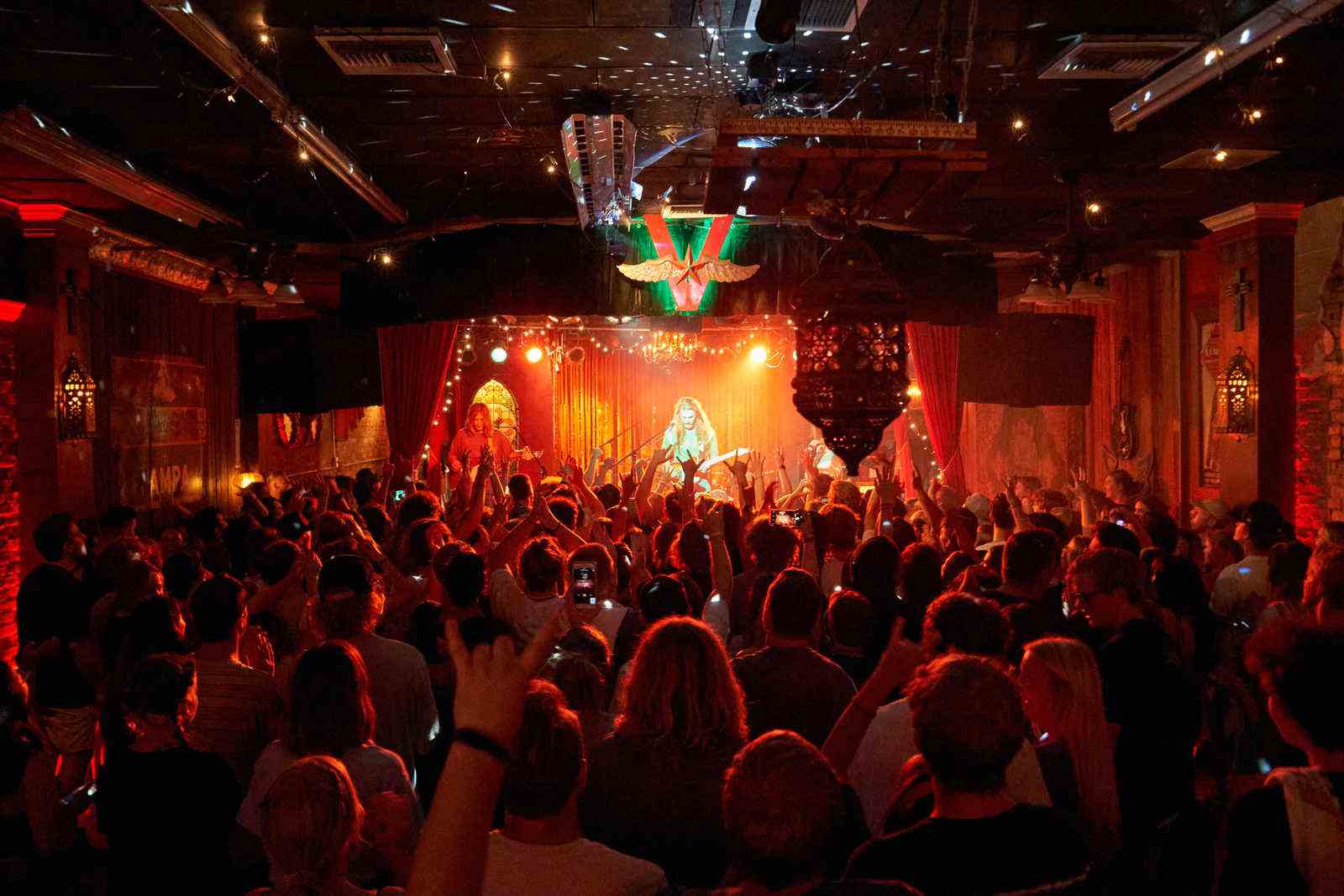 Concert hall with guitarist on stage and audience members