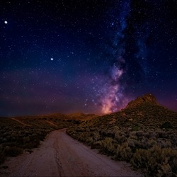 Dark night sky with stars above road