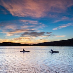 Two canoers on lake at sunset