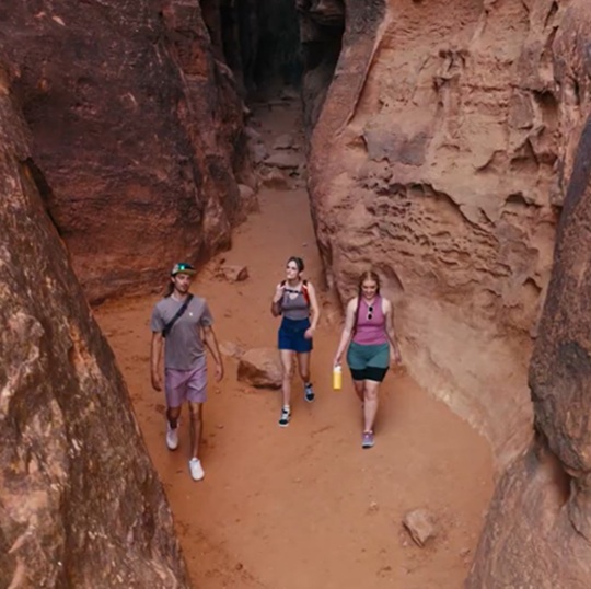 Man talking to a group of people around a campfire at night