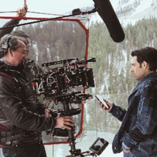 Movie camera filming a puppet with puppeteer in view