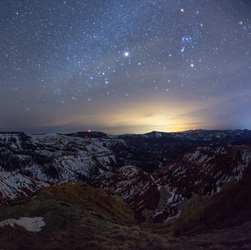 Night sky at sunset with stars over red rock mountain formations